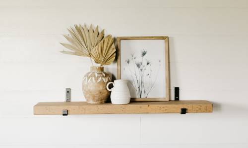 modern bracket shelf hanging on the wall holding small houseware items