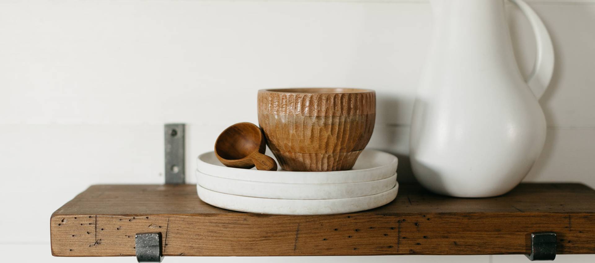 industrial shelf hanging on a wall holding housewares