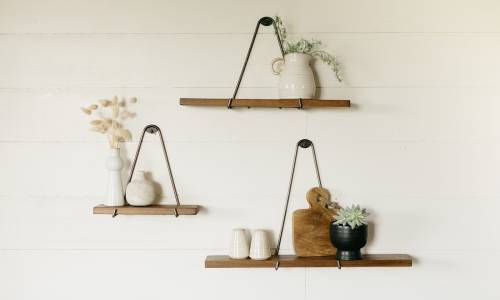 3 minimalistic floating shelves hanging on the wall with small houseware items on them