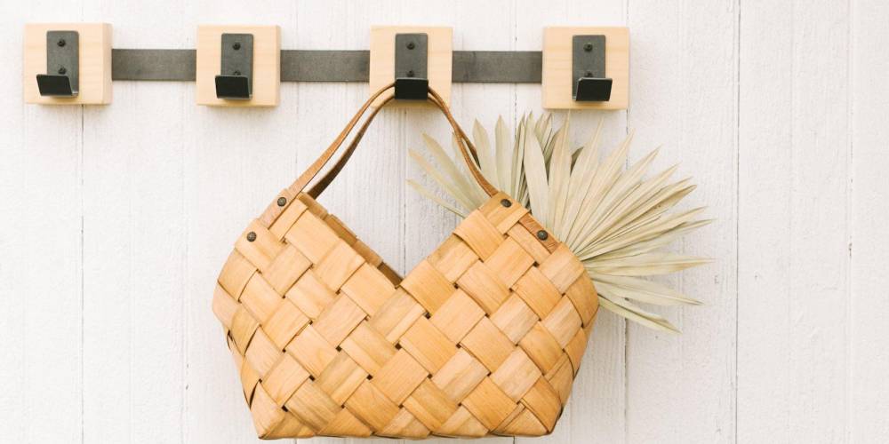 metal hooks on a hook rack holding a small basket with straps