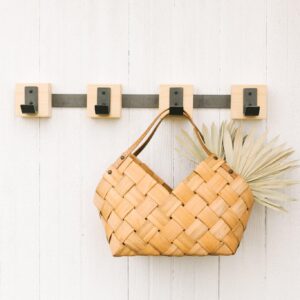 wood hook rack with metal hooks and bar holding a small wood basket