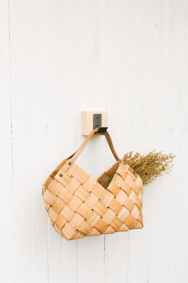 metal hook block hanging a wooden basket bag on the wall