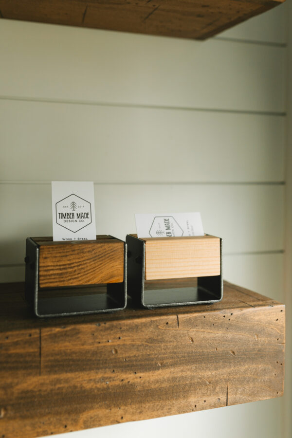 two small wooden business card holders. one is stained in dark walnut and one features a natural stain