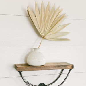 minimalistic wooden arch shelf holding a decorative piece