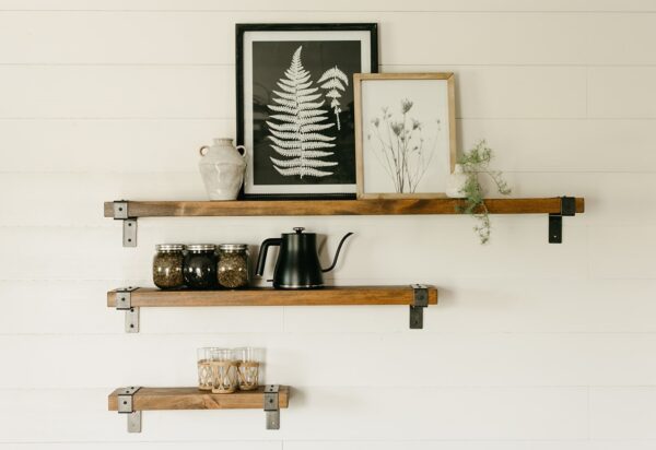 3 different sizes of wooden industrial shelves on a wall