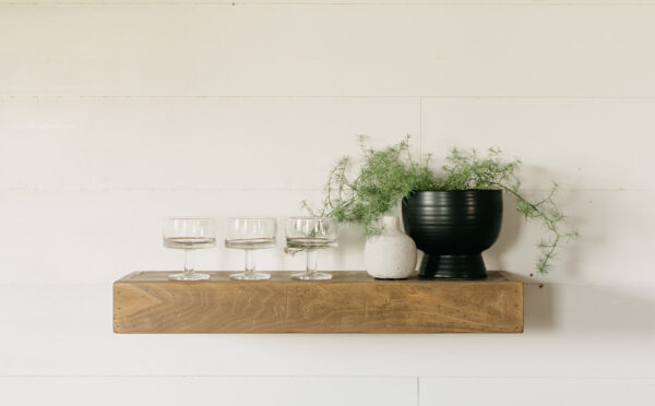 a floating shelf holding various housewares and a small planter
