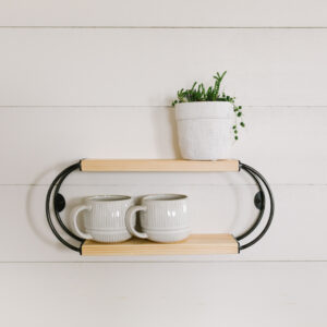 wooden oval shelf holding two coffee mugs and a small planter