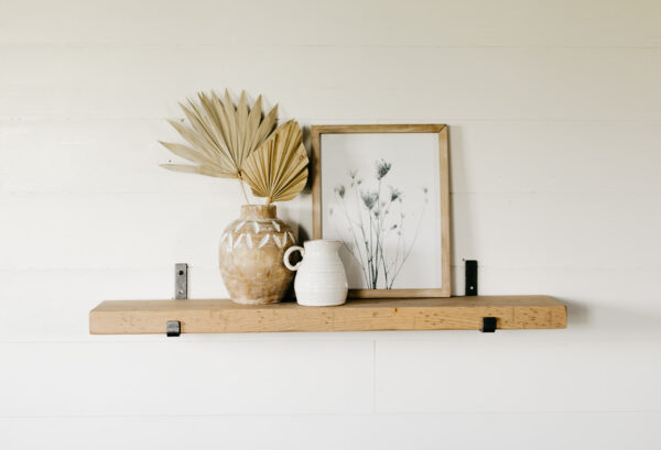 modern bracket shelf hanging on the wall holding small houseware items