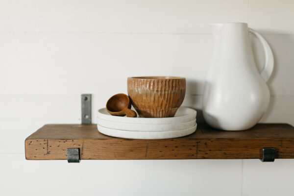 industrial shelf hanging on a wall holding housewares