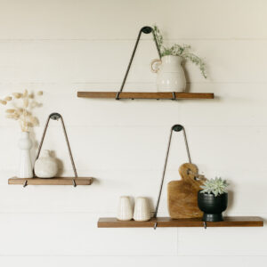 3 minimalistic floating shelves hanging on the wall with small houseware items on them