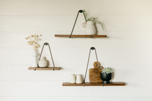 3 minimalistic floating shelves hanging on the wall with small houseware items on them